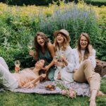 Women Sitting on Green Grass Field