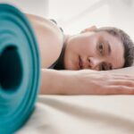 Tired woman lying on bed during workout