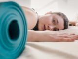 Tired woman lying on bed during workout