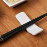 A Pair of Black Chopsticks on a White Chopstick Rest