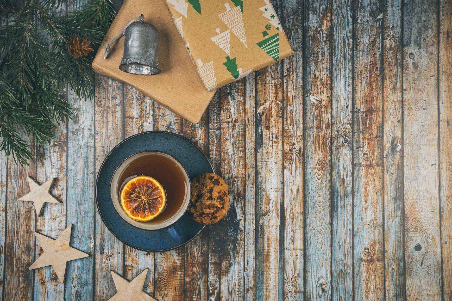 A cup of tea and a christmas tree on a wooden table