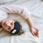 Woman in White Crew Neck T-shirt Lying on Bed