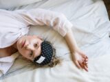 Woman in White Crew Neck T-shirt Lying on Bed