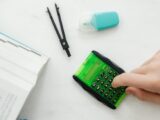 Person Using A Small Green and Black Calculator