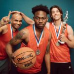 Three Men in Orange Jersey Shirt Holding Basketball