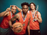 Three Men in Orange Jersey Shirt Holding Basketball