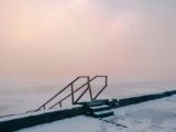 A stairway leading to the water at the edge of a frozen lake