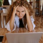 Photo of Woman Leaning on Wooden Table While Looking Upset