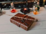 Brown Book and Wooden Stick on White Wooden Table