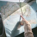 Person Wearing Beige Sweater Holding Map Inside Vehicle