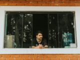 A man sitting in a window looking out