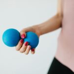 Faceless young woman with stress ball on white background