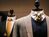 Dandy fancy jackets with shiny ties on dummies in showroom of contemporary male shop