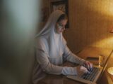 Woman in White Hijab Using Laptop Computer