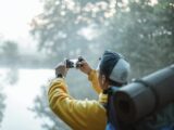 Person in Yellow Jacket Taking Photo in the Forest