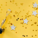 Golden Statuette and Stars on Yellow Background