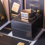 Rectangular Gold-colored Watch With Black Strap on Black Box