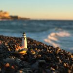 Close-up of Lighthouse Figurine on Rocks on the Beach